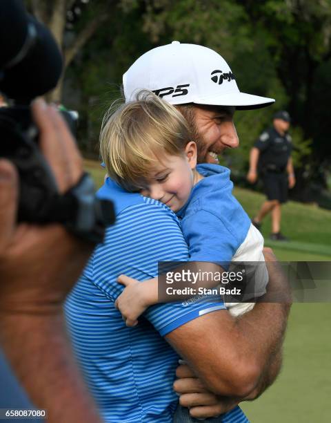Dustin Johnson of the United States receives a victory hug from his son Tatum on the 18th green after winning the championship match at the World...