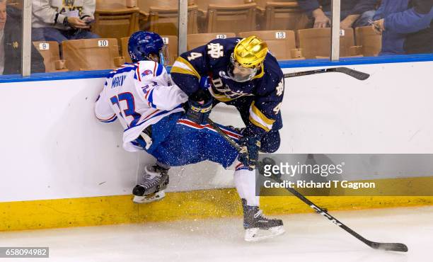 Nick Marin of the Massachusetts Lowell River Hawks is checked by Dennis Gilbert of the Notre Dame Fighting Irish during the NCAA Division I Men's Ice...
