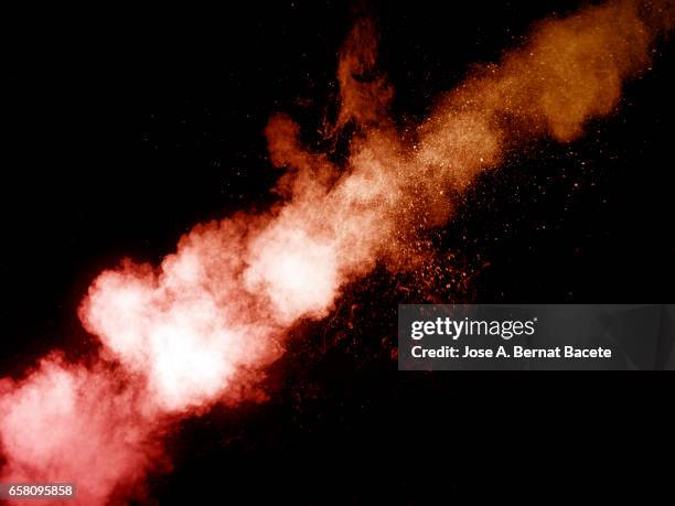 explosion of a cloud of powder of particles of  colors red and white on a black background - moverse hacia arriba stock-fotos und bilder