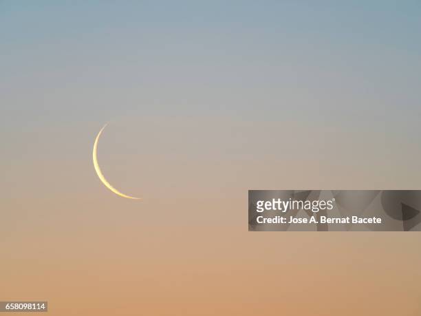 view of a gibbous moon on a clear blue and orange sky - escena no urbana stock-fotos und bilder
