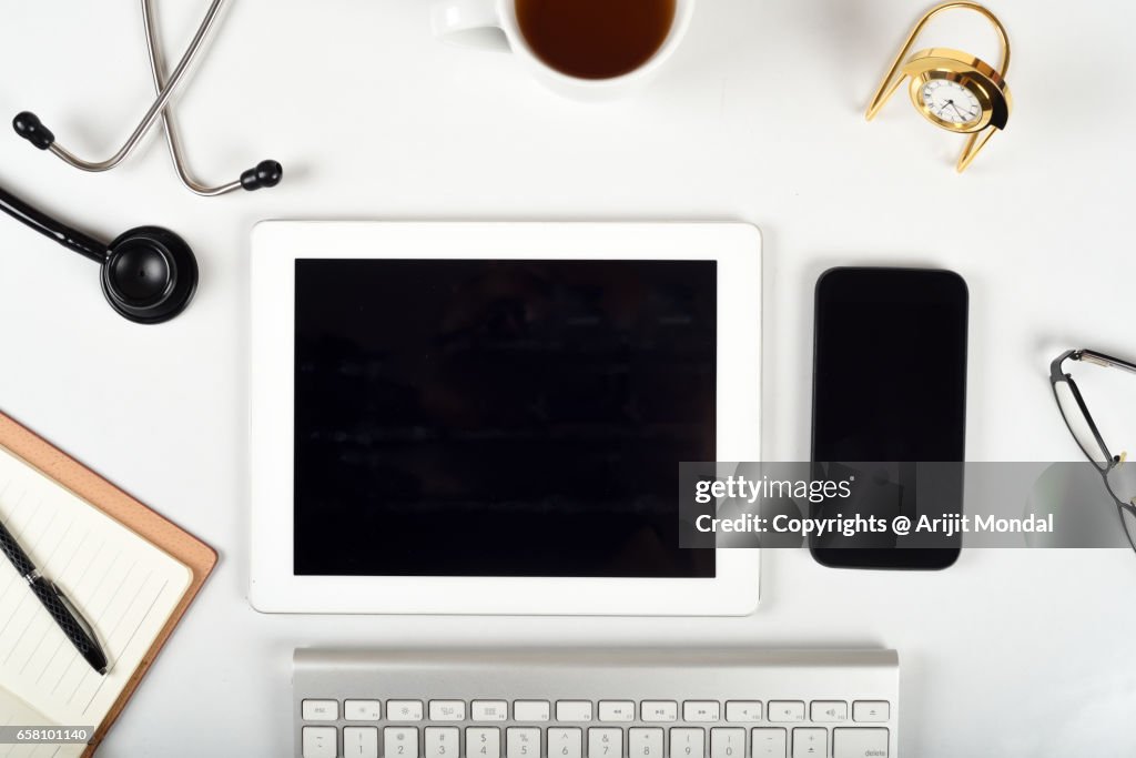 Top View Of Doctor Office Desk Table With Stethoscope And Lot Of Things, Copy Space