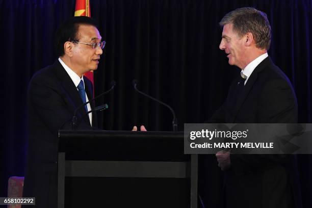 New Zealand's Prime Minister Bill English shakes hands with China's Premier Li Keqiang after a joint press conference in Wellington on March 27,...