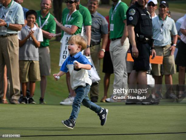 Tatum Johnson runs to his father Justin Johnson on the 18th green after the championship match at the World Golf Championships - Dell Technologies...