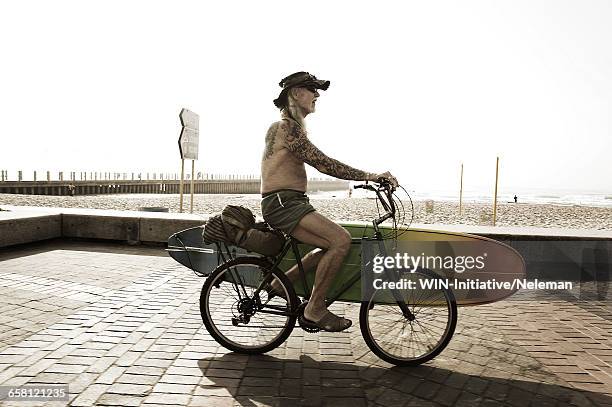 portrait of mature hippie surfer, cape town, south africa - surfboard tattoo stockfoto's en -beelden