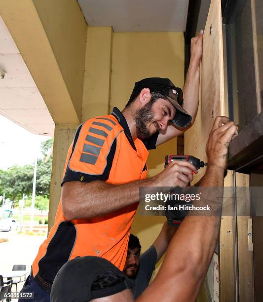 Workman puts up plywood panels to protect a shop on the Strand as residents prepare for Cyclone Debbie on March 27, 2017 in Townsville, Australia....