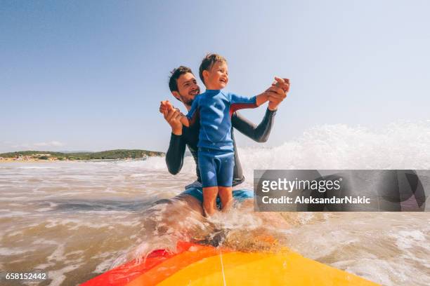 learning a surf - familia en la playa fotografías e imágenes de stock