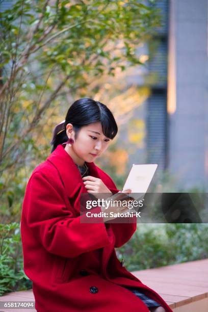 jeune femme regardant l’écran sur la tablette numérique - kyobashi tokyo photos et images de collection