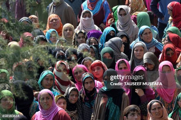 Kashmiri villagers watch the funeral procession of suspected rebel Shahbaz Shafi, also known as Rayees Kachroo, at Belov village in Pulwama, south of...