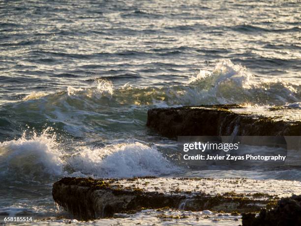 sea waves splashing on rock - mojado stock-fotos und bilder