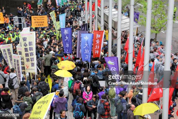 Pro-democracy protesters march the street outside the convention center where the Hong Kong chief executive election is being held on March 26, 2017...