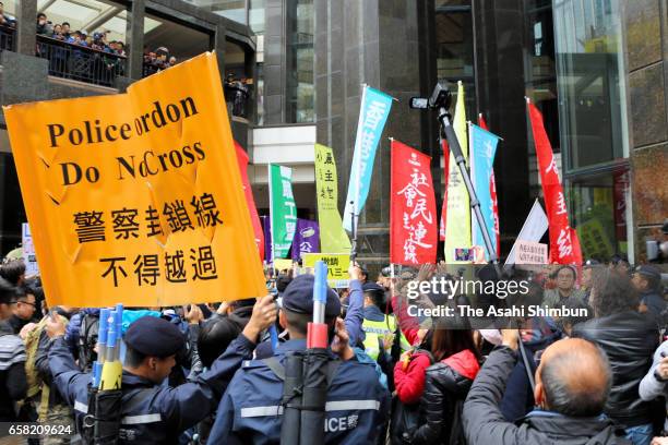 Pro-democracy protesters march the street outside the convention center where the Hong Kong chief executive election is being held on March 26, 2017...