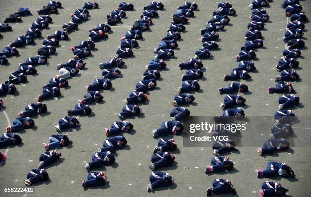 Students put hands on heads as they learn to protect themselves in a stampede at Hanshan Nagisa River Road Primary School on March 27, 2017 in...