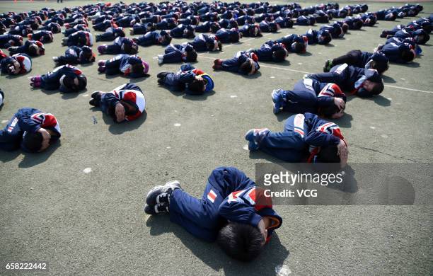 Students put hands on heads as they learn to protect themselves in a stampede at Hanshan Nagisa River Road Primary School on March 27, 2017 in...