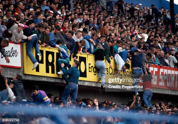 Football fans being lifted to safety from the central pens in the Leppings Lane stand allocated to Liverpool supporters during the start of the FA...