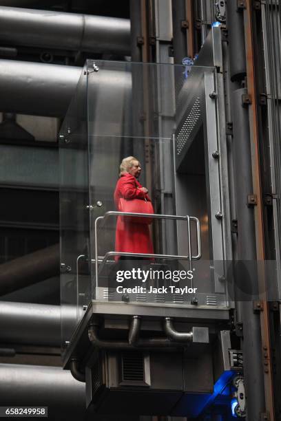 Woman rides an elevator in the Lloyd's building, home of the world's largest insurance market Lloyd's of London, on March 27, 2017 in London,...