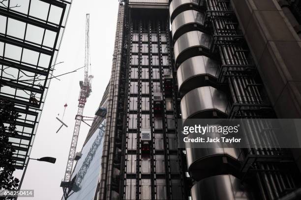 The Lloyd's building, home of the world's largest insurance market Lloyd's of London, is seen as a crane lifts metal beams on March 27, 2017 in...