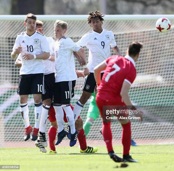Salih Oezcan, Robin Hack and Etienne Amenyido of Germany try to block a free-kick of Luka Adzic of Serbia during the UEFA Elite Round match between...