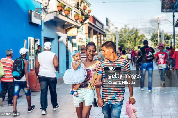 cuban people walking in the city centre of santiago de cuba - santiago de cuba stock pictures, royalty-free photos & images