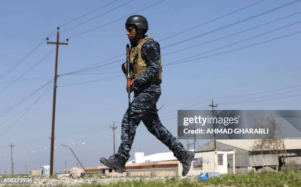 An Iraqi security forces member patrols as displaced Iraqis, who fled their homes in the Old City in western Mosul due to the ongoing fighting...