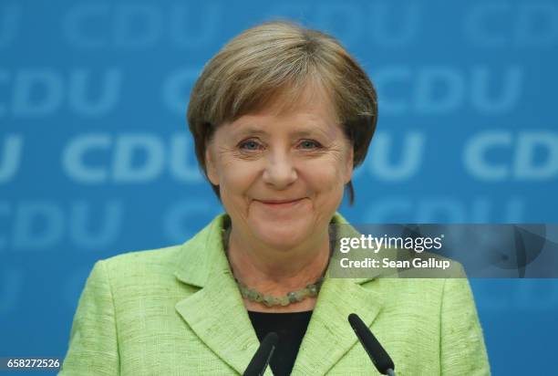 German Chancellor and Chairwoman of the German Christian Democrats Angela Merkel smiles while speaking to the media at CDU headquarters the day after...