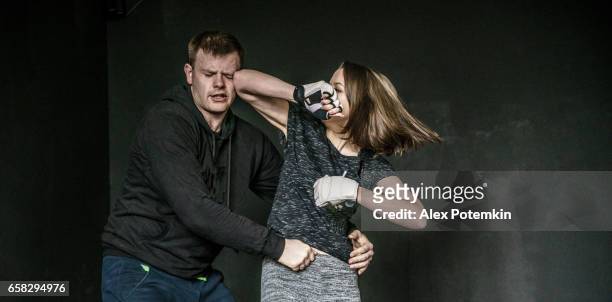 woman self-defense trick against the man's attack. strong women practicing self-defense martial art krav maga - punsch stock pictures, royalty-free photos & images