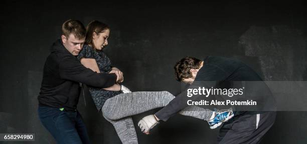 woman self-defense trick against the two man's attack. strong women practicing self-defense martial art krav maga - krav maga stock pictures, royalty-free photos & images