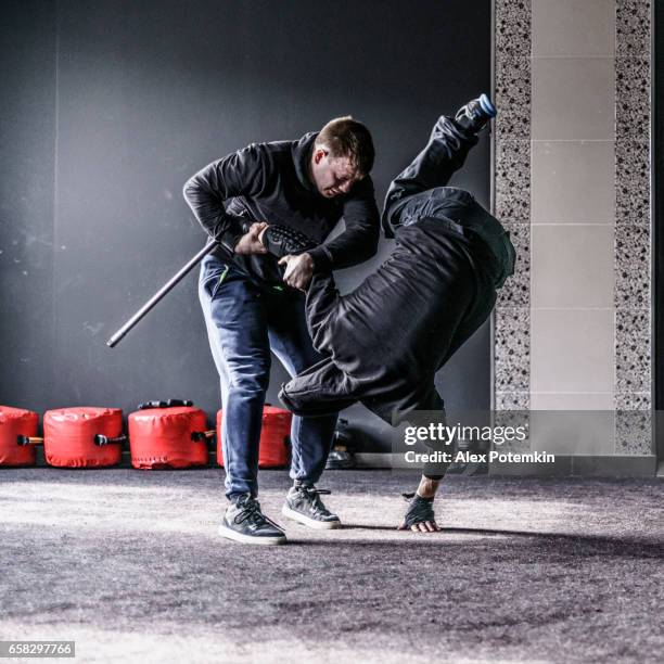 defense against the attack with a bet. the sequence of the move. krav maga practice: the self-defense martial art developed for the israel army. minsk, belarus. - krav maga stock pictures, royalty-free photos & images