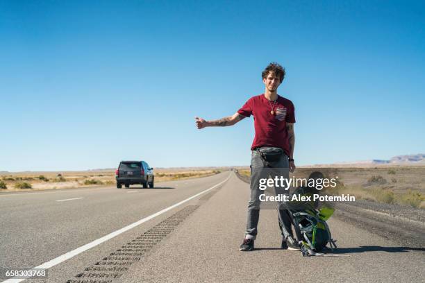 hombre joven, autostopista, buscando viaje en carretera, desierto de utah - autostop fotografías e imágenes de stock