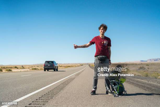 年輕人，漫遊，尋找騎在猶他州的沙漠公路上 - hitchhiking 個照片及圖片檔