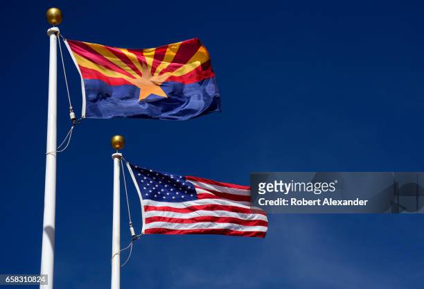 The Arizona state flag flies beside the United States flag at the Visitor Center at Canyon de Chelly National Monument near Chinle, Arizona....