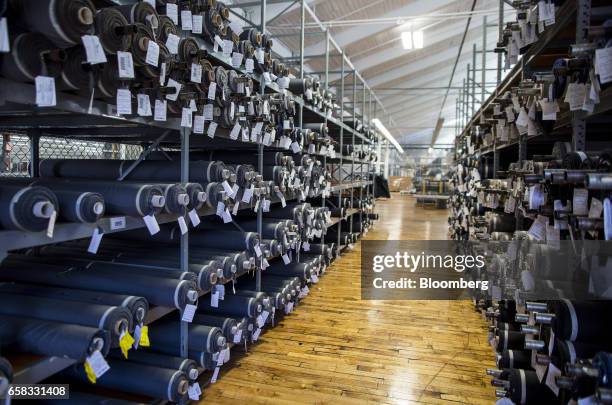 Rolls of fabric sit on shelves inside the Joseph Abboud Manufacturing Corp. Facility in New Bedford, Massachusetts, U.S., on Wednesday, March 22,...
