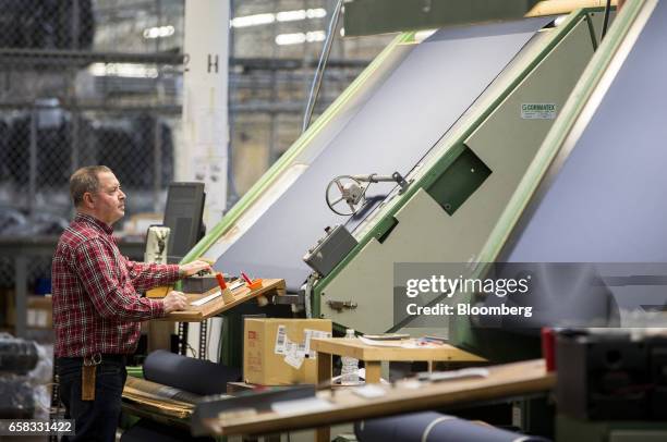 An employee performs a quality check on fabric at the Joseph Abboud Manufacturing Corp. Facility in New Bedford, Massachusetts, U.S., on Wednesday,...