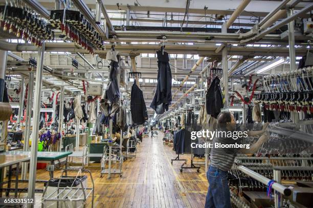 Suit jackets at various stages of production move along a track system at the Joseph Abboud Manufacturing Corp. Facility in New Bedford,...