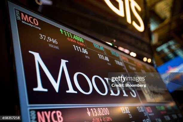 Monitor displays Moody's Corp. Signage on the floor of the New York Stock Exchange in New York, U.S., on Monday, March 27, 2017. U.S. Stocks fell,...