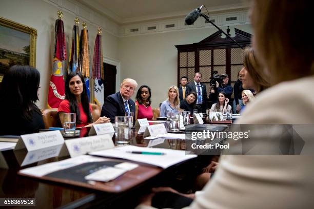 President Donald Trump, third left, and Ivanka Trump, daughter of Trump, center, listen during a meeting with women small business owners in the...