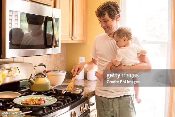 father and baby daughter in kitchen - gas stove cooking stock pictures, royalty-free photos & images