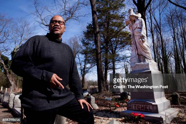 Musician John Mitchell stands at the edge of a family plot at the historic Evergreen Cemetery in Richmond. While the cemetery is largely abandoned,...