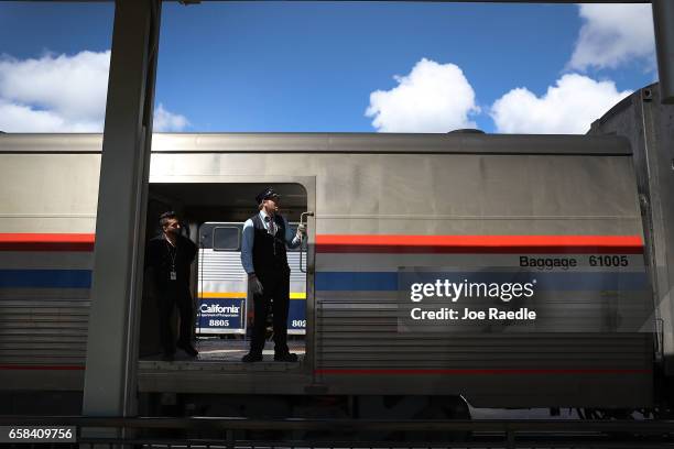 Conductor Evan Gerdes works on Amtrak's California Zephyr at a train stop during its daily 2,438-mile trip to Emeryville/San Francisco from Chicago...