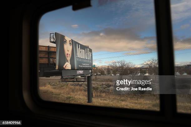 Billboard is seen as Amtrak's California Zephyr rolls through a town during its daily 2,438-mile trip to Emeryville/San Francisco from Chicago that...