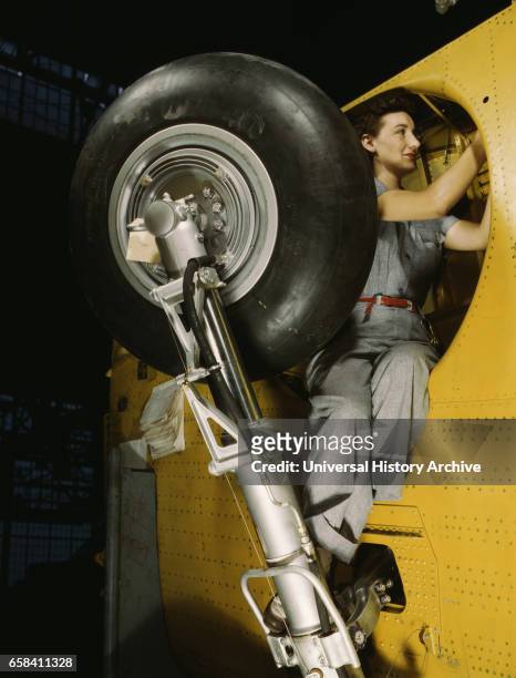 Female Worker Making Final Adjustments in Wheel Well of Inner Wing Before Installation of Landing Gear, Vultee "Vengeance" Dive Bomber, Nashville,...