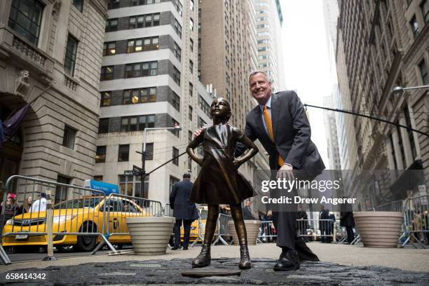 New York City Mayor Bill De Blasio poses for a photo with the 'Fearless Girl' statue during a press availability, March 27, 2017 in New York City. De...