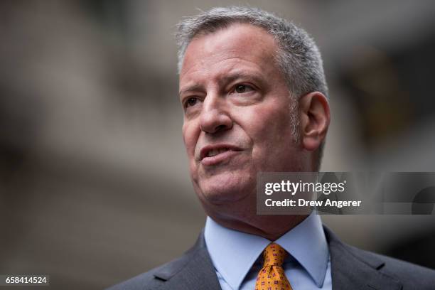 New York City Mayor Bill De Blasio speaks to reporters during a media availability with the 'Fearless Girl' statue, March 27, 2017 in New York City....