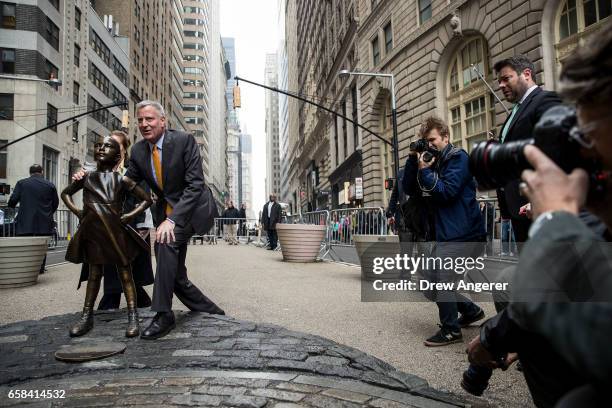 New York City Mayor Bill De Blasio poses for a photo with the 'Fearless Girl' statue during a press availability, March 27, 2017 in New York City. De...