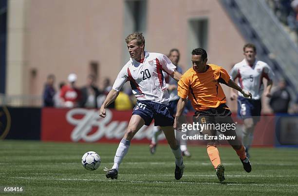 Forward Brian McBride of the USA chases the ball ahead of midfielder Danny Landzaat of Holland during the game at CMGI Field in Foxboro,...
