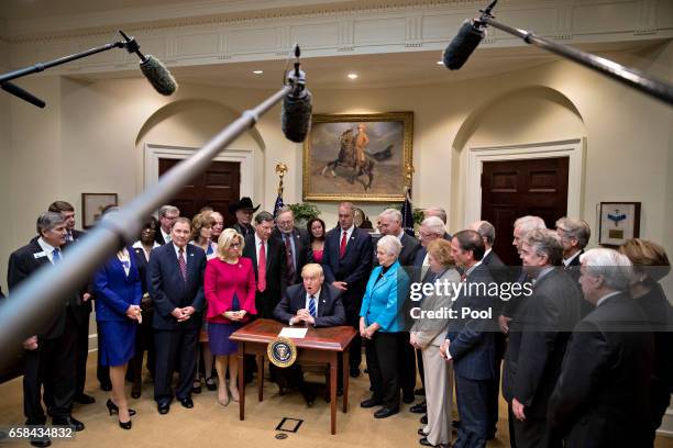 President Donald Trump, center, speaks during a bill signing ceremony in the Roosevelt Room of the White House March 27, 2017 in Washington, D.C....