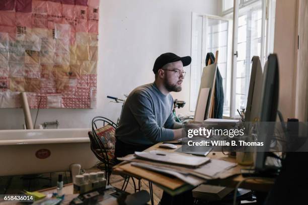 young creatives man working in home office - creative desk stock-fotos und bilder