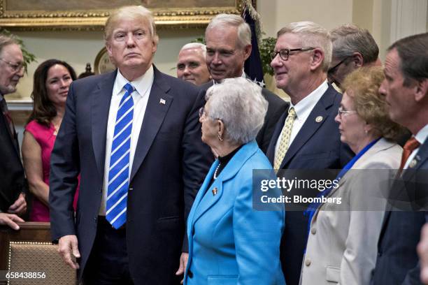 President Donald Trump, left, stands after signing bills in the Roosevelt Room of the White House in Washington, D.C., U.S., on Monday, March 27,...