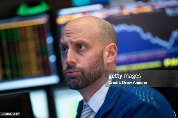 Trader works at his desk on the floor of the New York Stock Exchange ahead of the closing bell, March 27, 2017 in New City. Today marked the eighth...