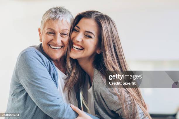 gelukkig volwassen moeder en dochter omarmen - happy smiling family stockfoto's en -beelden