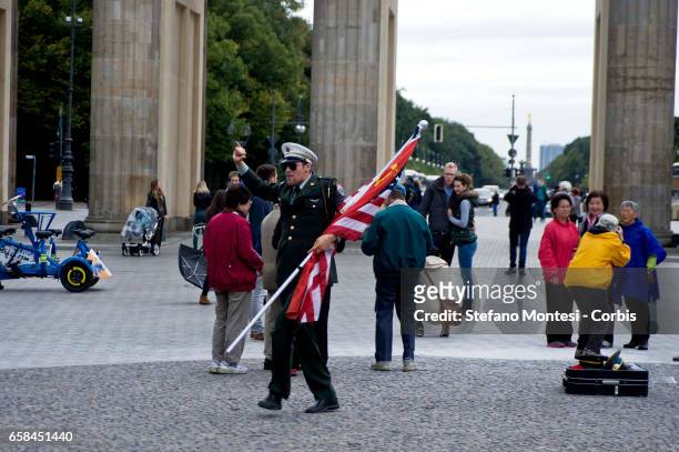 Actor playing a United States Army military policeman poses for tourist photographs in front of the Brandenburg Gate, in the center of Berlin on...